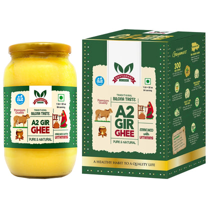A glass bottle filled with golden A2 cow ghee, accompanied by its packaging box featuring brand logo and product information.